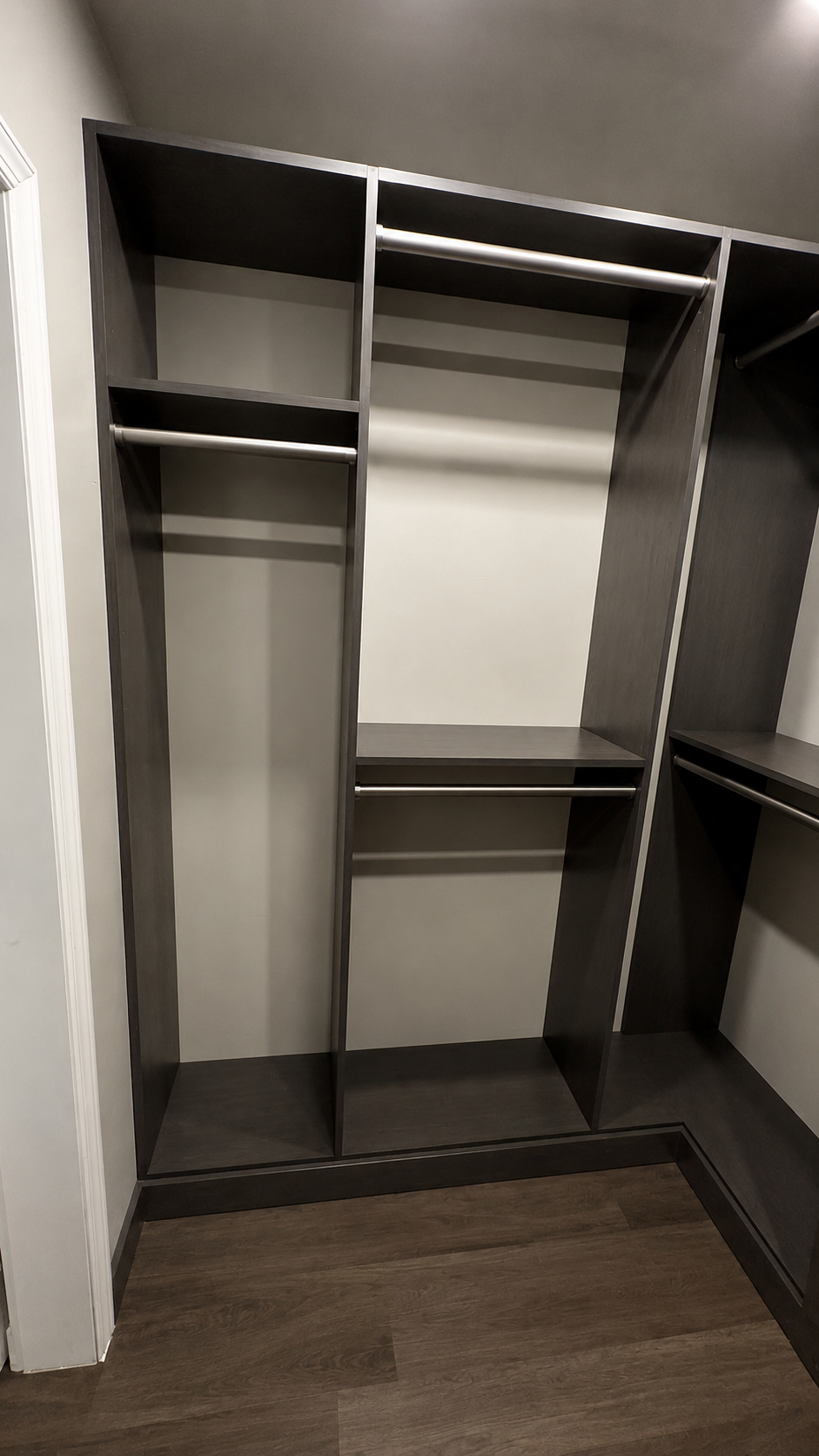 Dark espresso walk-in wardrobe with stainless rods and open hanging bays