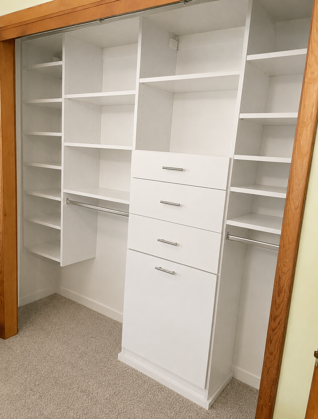 White closet organizer with drawer tower, shelving, and double hanging sections