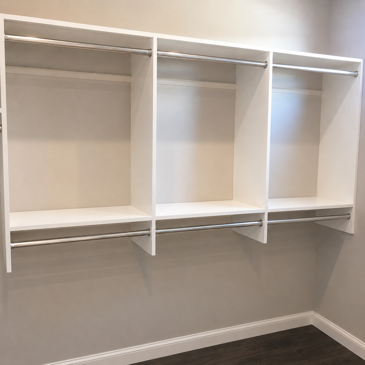 Three-bay white wall-mounted closet system with double chrome hanging rods